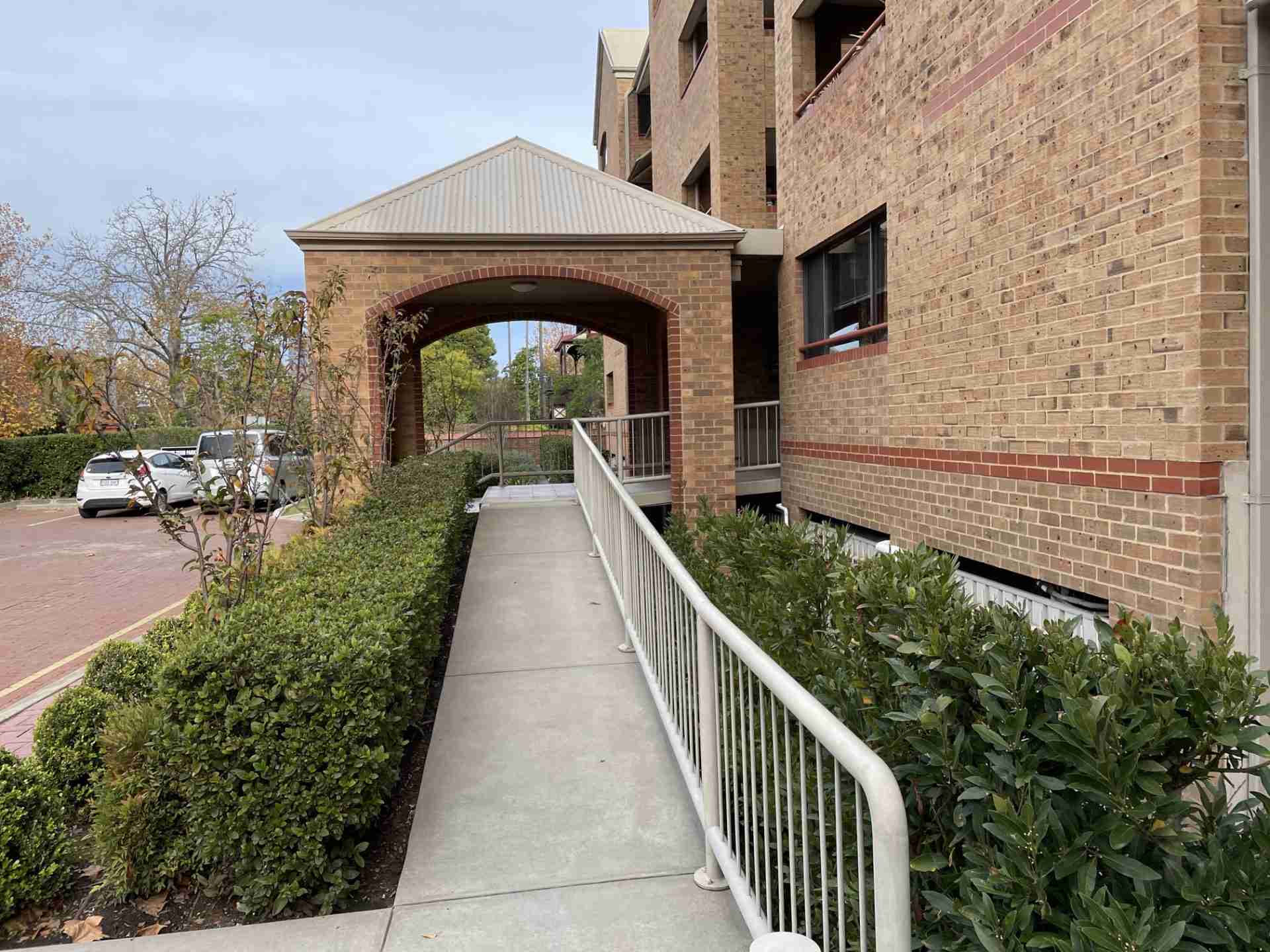 Jeffcott-Street-Strata-Clean An entrance ramp to a beige brick residential apartment block after a high-pressure strata clean