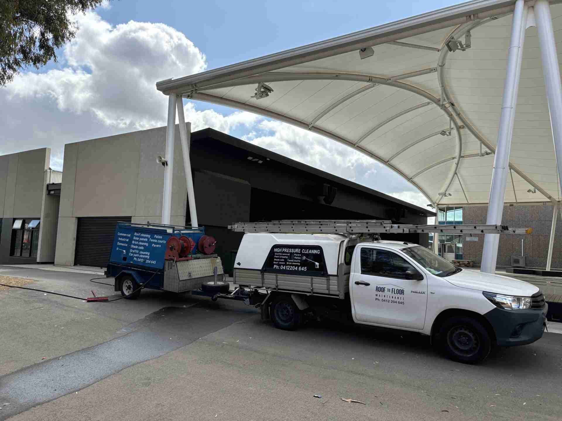 Gawler-pressure-cleaning-case-study The Roof to Floor Maintenance ute and trailer are parked in front of a large white canopy at the Gawler and District College.
